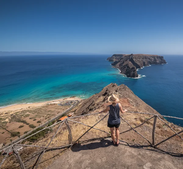 A woman looking out from a quiet clifftop viewpoint over the island of Ilhéu de Cima