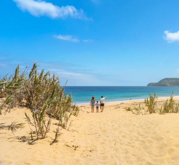 A family walking toward the sea at Praia da Lagoa in Porto Santo